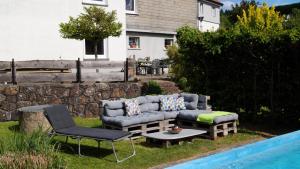 a couch and a table and a chair next to a pool at Ferienwohnung Kebben in Kirchhundem