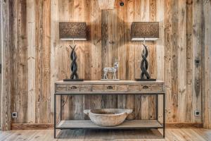 a wooden wall with two lamps and a bowl on a table at Chalet Charvin in Megève +21 photos