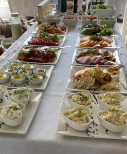 Farma Bii في Brzeziny: طاولة طويلة مع العديد من أطباق الطعام عليها
