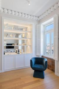 sala de estar con silla azul y ventana en Agora Suites en Athens