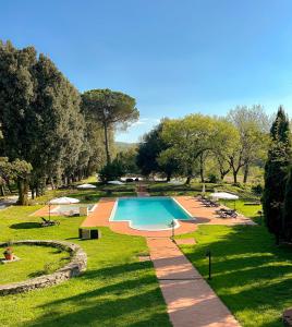 a swimming pool in the middle of a park at Villa Mucellena in Casole dʼElsa
