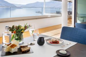 a table with a plate of food and wine glasses at Casa Berno Panorama Resort in Ascona