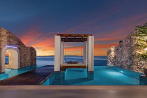 a bedroom in a villa with a view of the ocean at Emerald Villas & Suites - The Finest Hotels Of The World in Agios Nikolaos