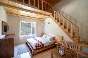 1 dormitorio con 1 cama y escalera en The Dargeli's Lodge, Manali en Haripūr