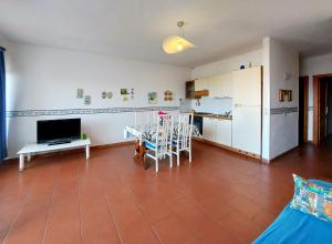 a living room with a table and a kitchen at Casa Paola Cala Lupo in Stintino