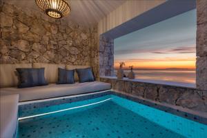 a pool in a room with a view of the ocean at Emerald Villas & Suites - The Finest Hotels Of The World in Agios Nikolaos