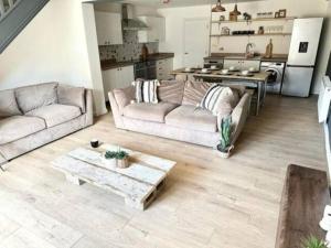 sala de estar con 2 sofás y cocina en New Stunning 5 Bedroom House-Wi-Fi-Parking-Slps 12 en Stroud