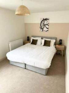 a bedroom with a white bed and a chandelier at New Stunning 5 Bedroom House-Wi-Fi-Parking-Slps 12 in Stroud
