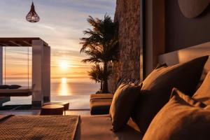 a living room with a couch and a view of the ocean at Emerald Villas & Suites - The Finest Hotels Of The World in Agios Nikolaos