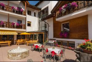 an outdoor patio with tables and chairs and a fountain at Hotel Tonnerhof in Racines