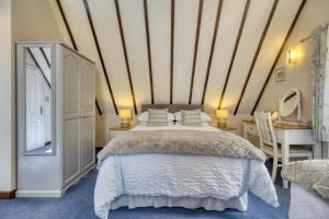 een slaapkamer met een bed, een tafel en een bureau bij Augusta Cottage in Bourton on the Water