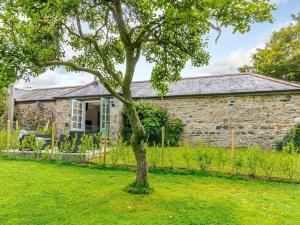 a stone cottage with a tree in front of it at 2 Bed in Falmouth 78620 in Penryn