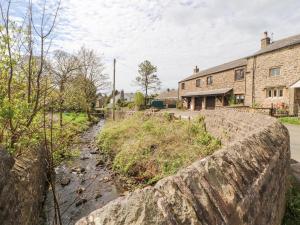 an old stone wall in a village with houses at Barn Cottage in Carnforth