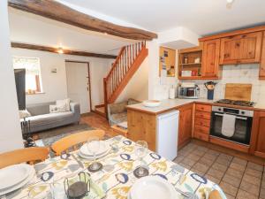 a kitchen and living room with a table and chairs at Barn Cottage in Carnforth