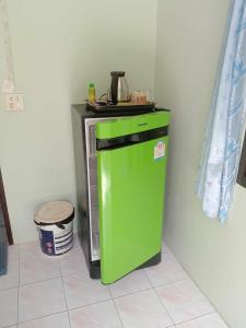 a green refrigerator sitting next to a wall at kamrai resort apartment in Ban Bang Bao