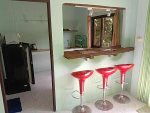 a pair of red stools in a kitchen with a mirror at kamrai resort apartment in Ban Bang Bao