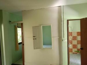 Zimmer mit einem Spiegel an der Wand und einer Tür in der Unterkunft kamrai resort apartment in Ban Bang Bao