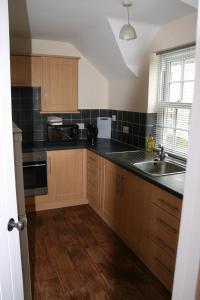 a kitchen with wooden cabinets and a sink at Hawthorn in Crayke YO61 4TE in York