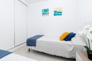 a bedroom with a bed with blue and yellow pillows at Flamenco Village Elvira in Orihuela +29 photos