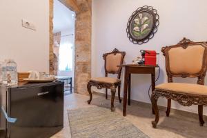 una stanza con due sedie, un tavolo e uno specchio di Casa Ifestou a Città di Rodi