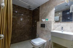 La salle de bains est pourvue de toilettes, d'un lavabo et d'une douche. dans l'établissement Gorakha Hotel Pvt Ltd, à Itahari