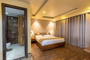 a bedroom with a bed and a bathroom with a shower at Gorakha Hotel Pvt Ltd in Itahari