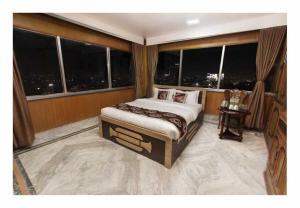 a bedroom with a large bed in a room with windows at Gorakha Hotel Pvt Ltd in Itahari