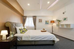 um quarto com uma cama grande e uma janela em Hideout Nimman em Chiang Mai