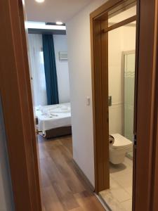 a room with a bathroom with a toilet and a bed at Double Comfort Otel in Muğla