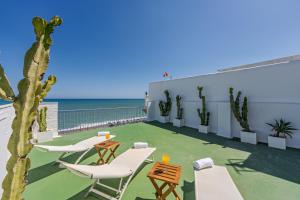 une terrasse avec des chaises et des tables et l'océan dans l'établissement CARIHUELA - Beach & Sun, à Torremolinos