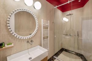 a bathroom with a sink and a mirror and a shower at Agora Suites in Athens