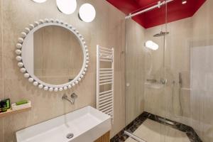 a bathroom with a sink and a mirror and a shower at Agora Suites in Athens +31 photos