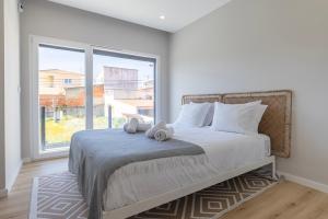 a bedroom with a bed with a large window at Poolside oasis by Caparica beach in Charneca