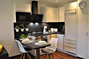 ミュンスターにあるCharmante Zimmer Wohnung Stilvollのキッチンにテーブルと椅子がある +2枚の写真