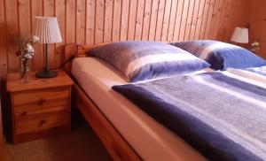 Duas camas num quarto com uma mesa de cabeceira e um candeeiro. em Ferienhaus Spatz 1 