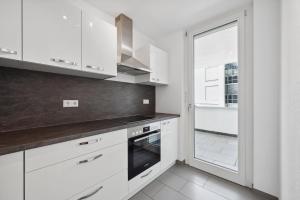 a white kitchen with white cabinets and a window at EXQUIS 4BR Design Apart-Haus I 2 Parken I Balkon in Böblingen