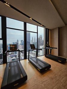 a gym with two treadmills and a view of a city at Maxx Royal Suites at Axon Kuala Lumpur in Kuala Lumpur