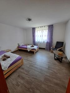 a bedroom with two beds and a chair and a window at Wohnung mit 2 Zimmern in Ballenberg