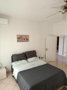 een slaapkamer met een bed en een witte muur bij L'appartamento delle vacanze in Venturina Terme