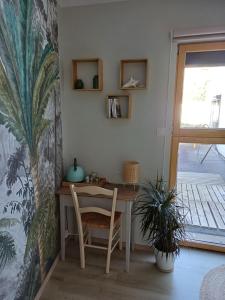 a table and chair in a room with a plant at Couettes et Mouettes in Lampaul-Plouarzel