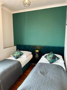 2 camas en una habitación con una pared azul en Skalny Widok en Hucisko