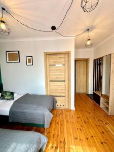 1 dormitorio con 2 camas y suelo de madera en Skalny Widok en Hucisko