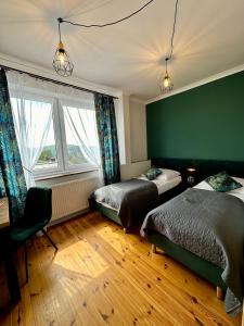 1 dormitorio con 2 camas y pared verde en Skalny Widok en Hucisko