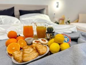 una bandeja de alimentos para el desayuno y bebidas en una cama en Vicoletto Fiorito, en Porto Empedocle
