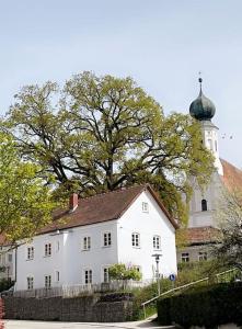 a large white house with a tower and a church at Zauberhaftes Haus in Ortenburg in Ortenburg
