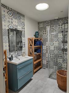 La salle de bains est pourvue d'un lavabo bleu et d'une douche. dans l'établissement Chez Nini et Didi 10 pers proche plage au calme, à Andernos-les-Bains