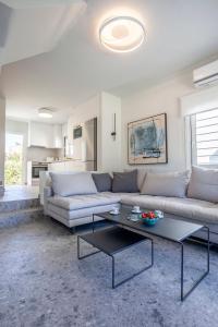 a living room with a couch and a table at Serenity Seafront garden villa in Pefkohori