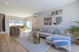 a living room with a couch and a table at Poolside oasis by Caparica beach in Charneca