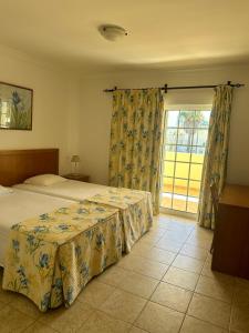 1 dormitorio con cama y ventana grande en Benvindo Villa en Albufeira