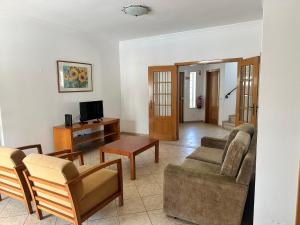 sala de estar con sofá y TV en Benvindo Villa en Albufeira